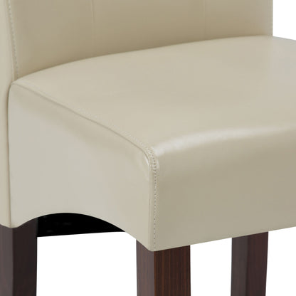 Close-up of the Cosmopolitan Deluxe Tufted Parson Upholstered Chair seat, featuring cream-colored fabric, wooden legs, smooth stitching, and curved edges.