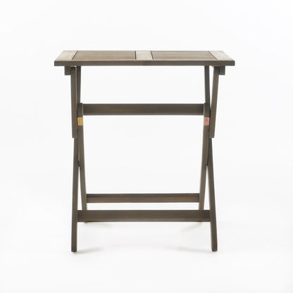 The Positano - Foldable Dining Set is a simple rectangular wooden table with horizontal slats on the tabletop and crossed legs, displayed against a plain white background.