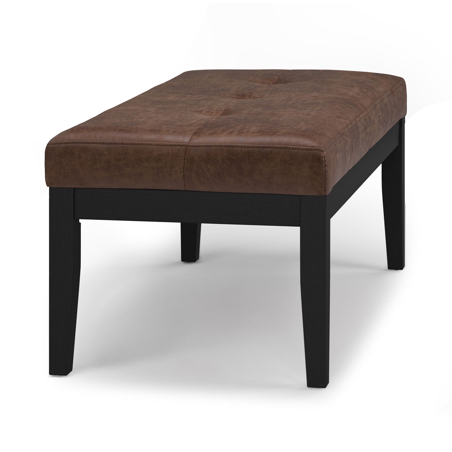 The Lacey - Upholstered Tufted Ottoman Bench features a rectangular cushioned brown leather seat with four black wooden legs, displayed against a plain white background.