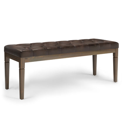 The Waverly - Upholstered Tufted Ottoman Bench features a dark brown tufted leather cushion and four wooden legs, displayed against a white background.
