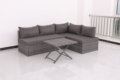 The Patio Sofa With Cushions - Gray and a matching rattan-style coffee table are placed on a white tiled floor in a bright, minimalist room with white walls and a metal railing.
