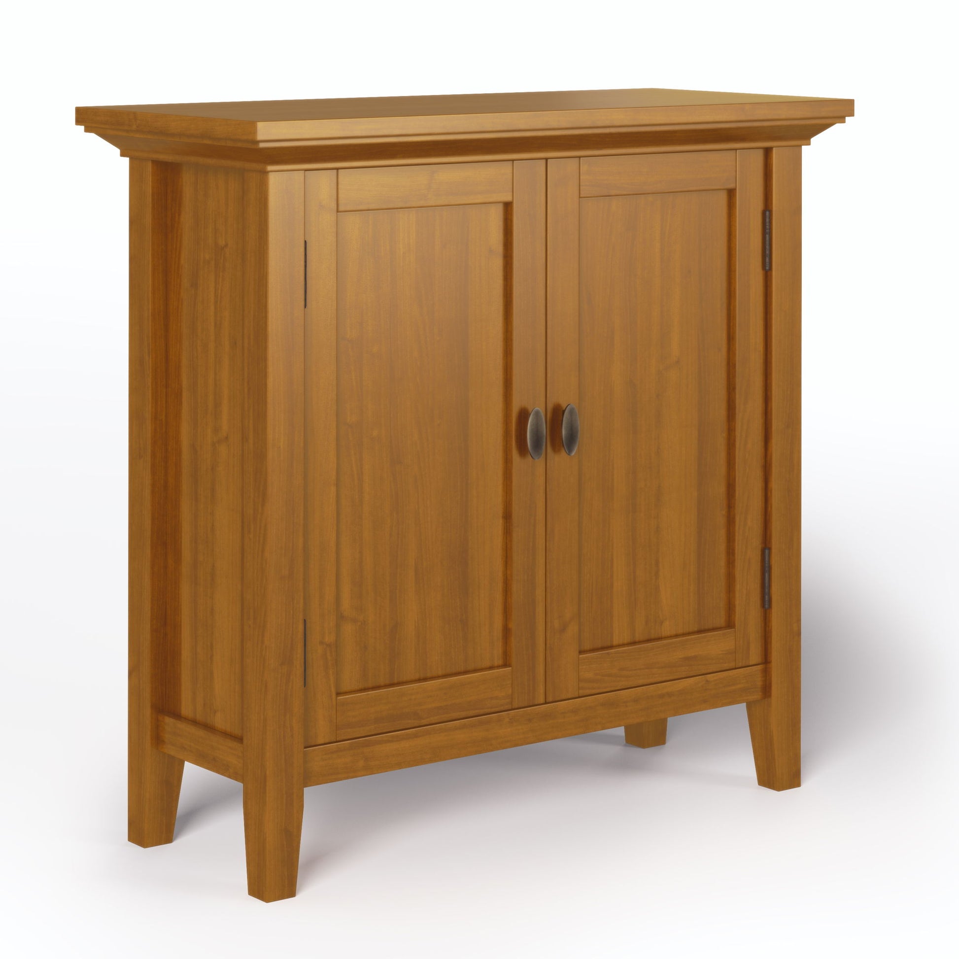 The Redmond Handcrafted Low Storage Cabinet features a natural wood finish, two paneled doors with round metal handles, and four straight legs, shown against a white background.