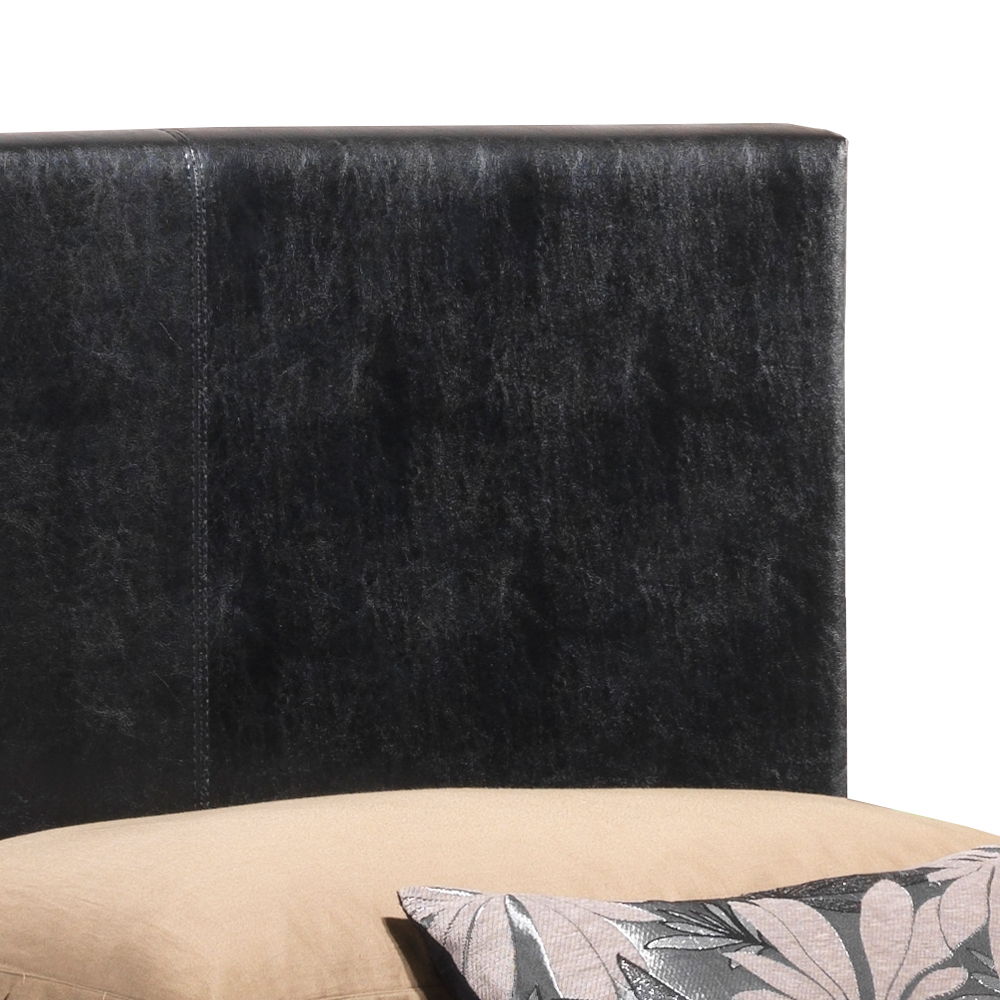 A close-up of the Elegant Platform Bed For Relaxed Spaces shows its black leather headboard, a beige mattress, and a decorative pillow with a gray and black floral pattern in the lower right corner.