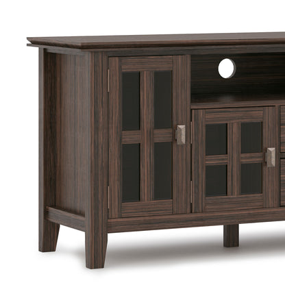 The Artisan TV Media Stand features a dark wood finish, glass-paneled cabinet doors with metal handles, an open shelf with a cable management cutout, modern clean lines, and sturdy legs for contemporary style and function.