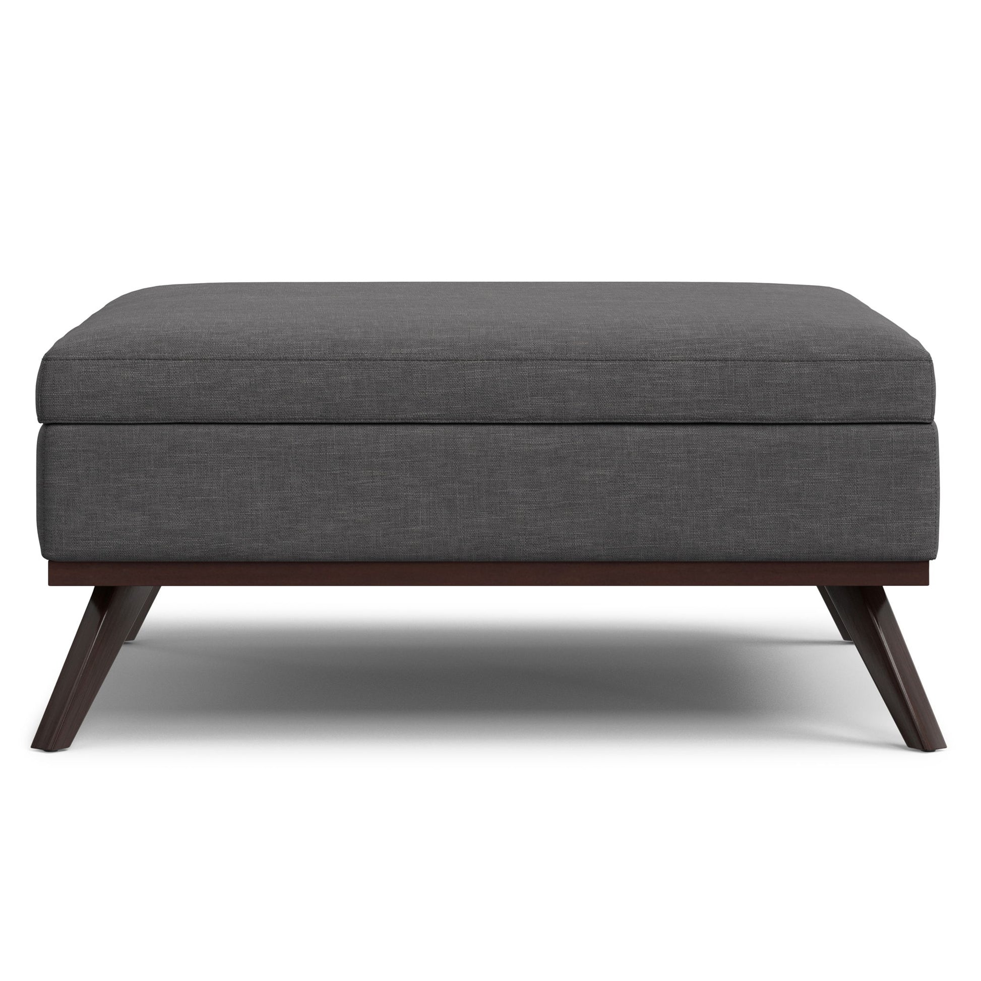 The Owen Multifunctional Square Coffee Table Storage Ottoman features a modern design with dark gray upholstery, a cushioned top, and angled wooden legs, shown from the front against a white background.