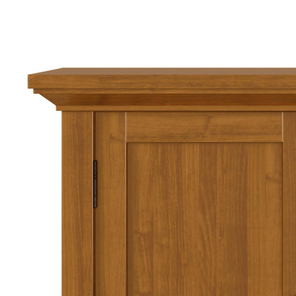 Close-up of the upper corner of the Redmond - Handcrafted Low Storage Cabinet, showing its light brown finish, flat top, and simple panel door design.