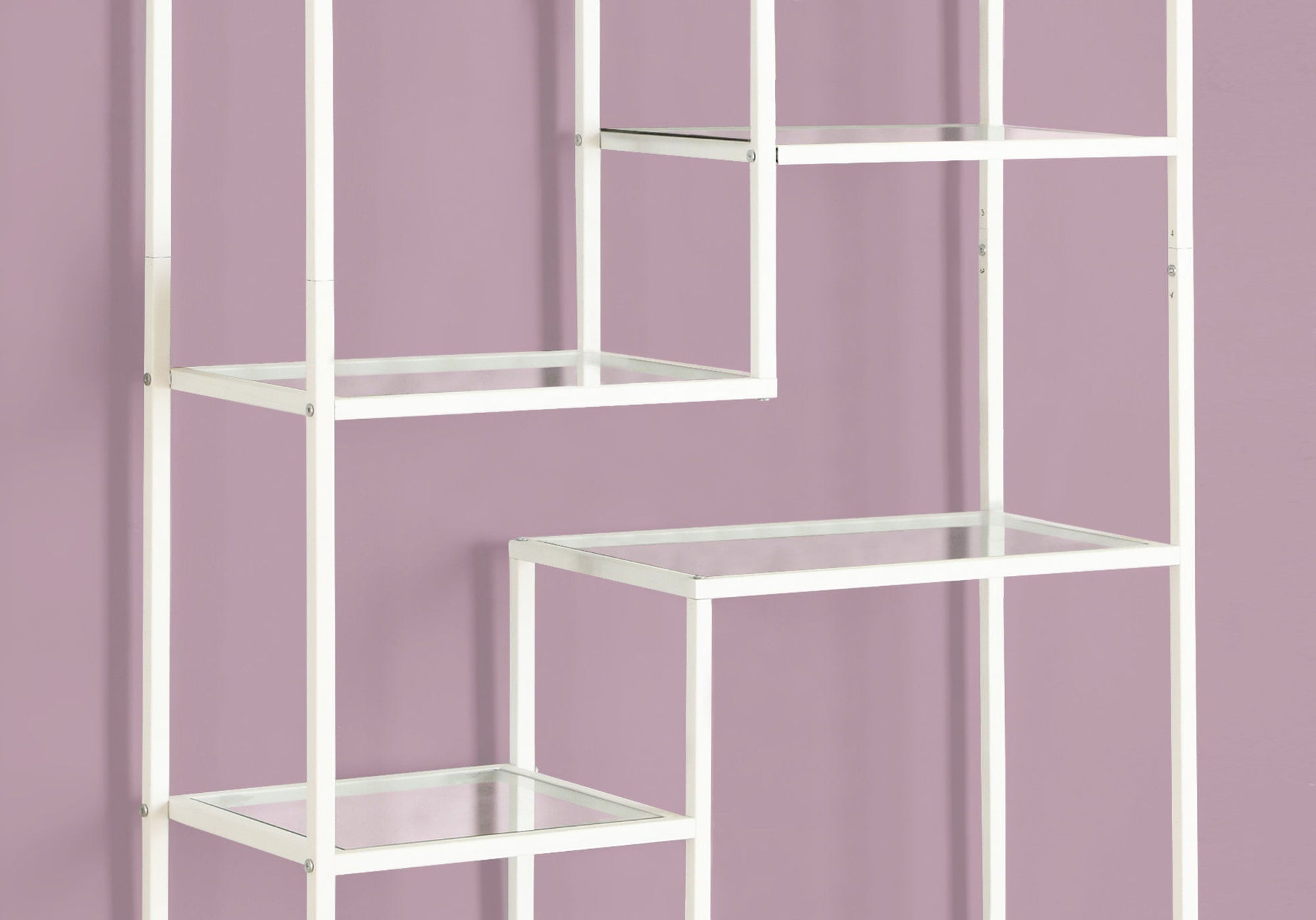 A contemporary white metal bookshelf with staggered rectangular glass shelves and open sides stands against a light mauve wall, featuring minimalist lines. Ideal as a bookcase or etagere for office or modern spaces.