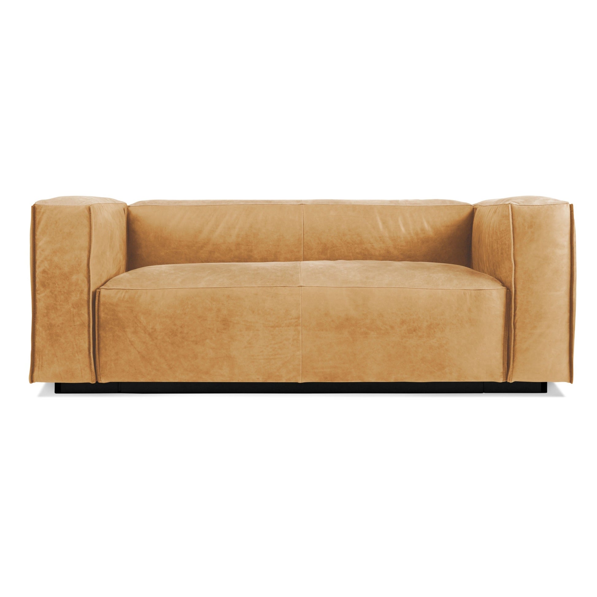 The Cleon Leather Armed Sofa in Camel Leather features a modern, boxy silhouette with broad armrests and a low backrest. Its minimalist, contemporary design includes smooth, clean lines and is displayed against a white background.