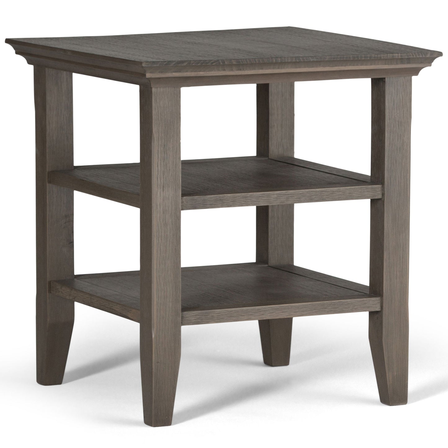 The Acadian - Handcrafted End Table features a rectangular wooden top, two lower shelves, four tapered legs, and a grayish-brown finish for a simple, modern look.
