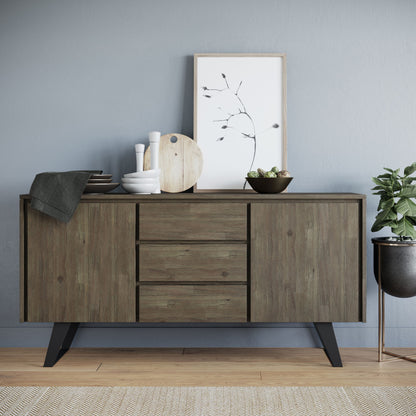 The Lowry - Handcrafted Sideboard Buffet, featuring three drawers and cabinets, stores dishes, bowls, a cutting board, and a framed botanical print. A potted plant sits on the floor to the right, while a textured rug covers the wooden flooring.