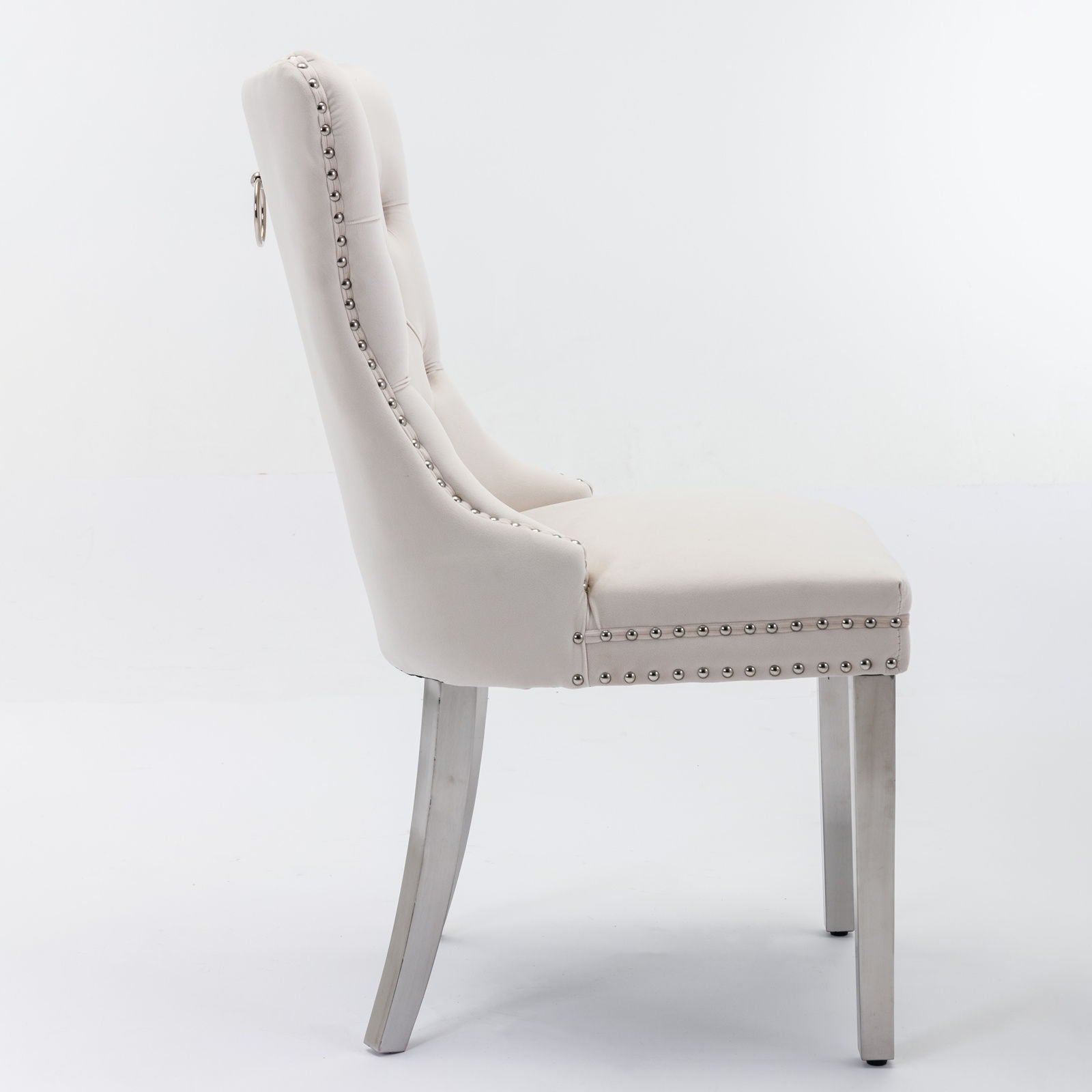 The Nikki dining chair set features high-end tufted velvet upholstery, a tall back, nailhead trim, and chrome stainless steel legs, shown in side view against a plain white background.