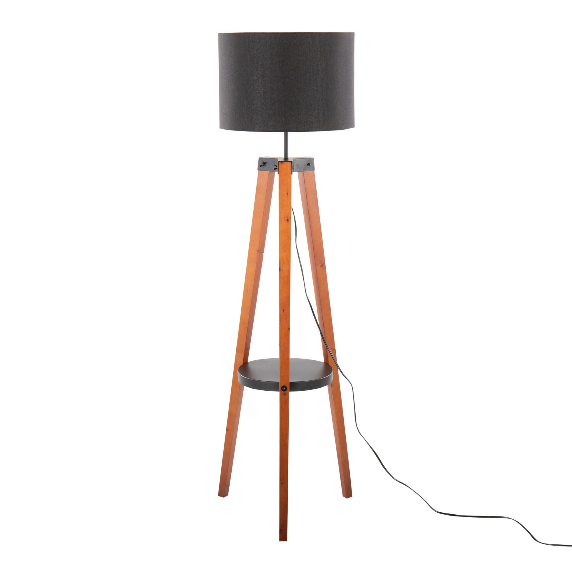 The Compass Mid Century Modern Floor Lamp features a black drum shade, wooden tripod legs, a round black shelf at the center, and a black power cord extending from its base.