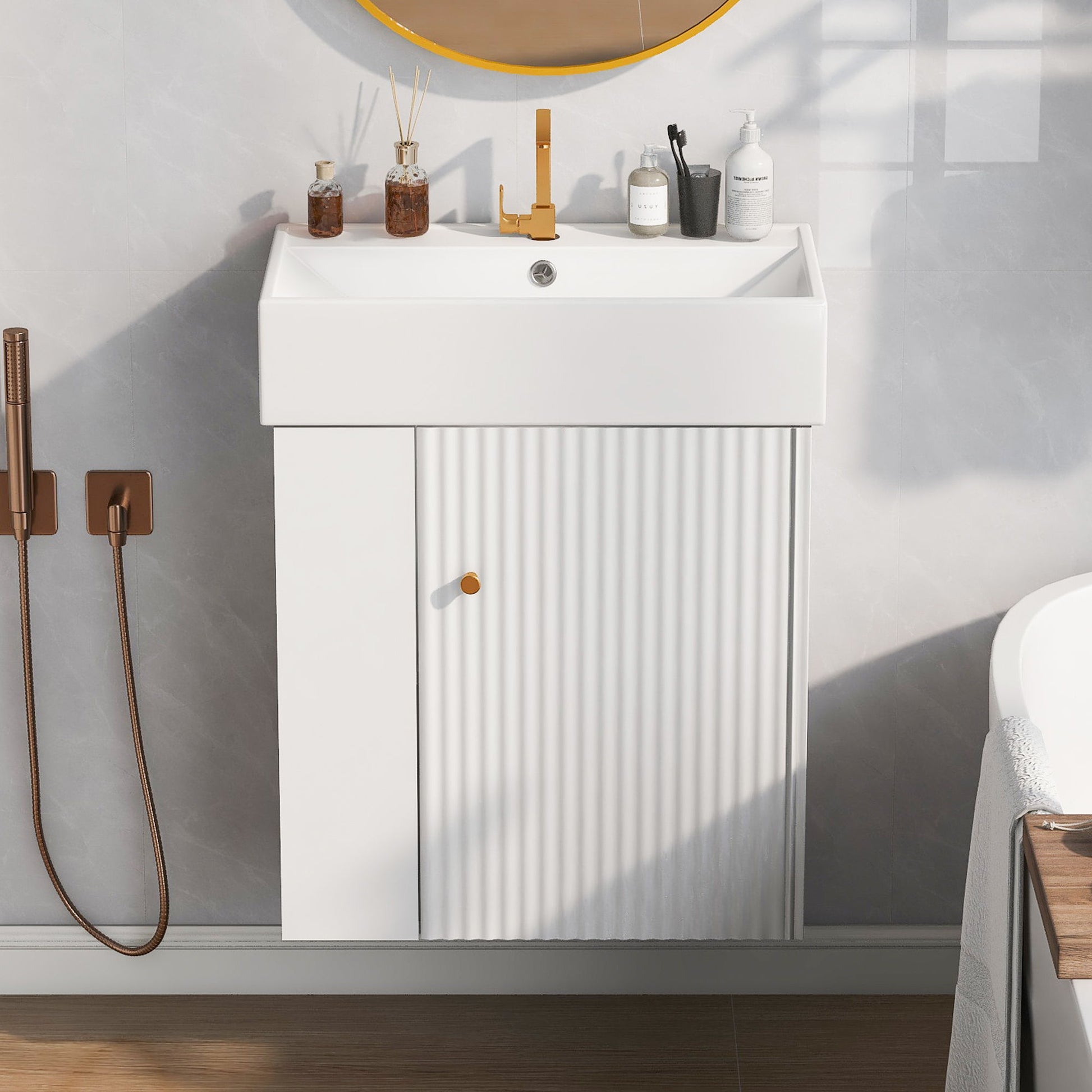 The Modern Floating Bathroom Vanity With Ceramic Basin is shown with a ridged white cabinet, gold faucet, and toiletries. Sunlight casts shadows as a gold shower fixture accents the adjacent wall—ideal for small bathrooms.