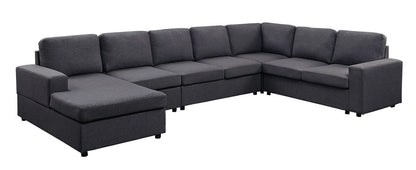 The Hayden Linen 7 Seat Reversible Modular Sectional Sofa Chaise is a large, L-shaped dark gray sofa with seven seat and back cushions plus a left-side chaise, set against a white background.