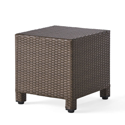 The Puerta Minimalist Style Accent Table features a square silhouette, woven brown rattan design, and short legs, shown against a plain white background.
