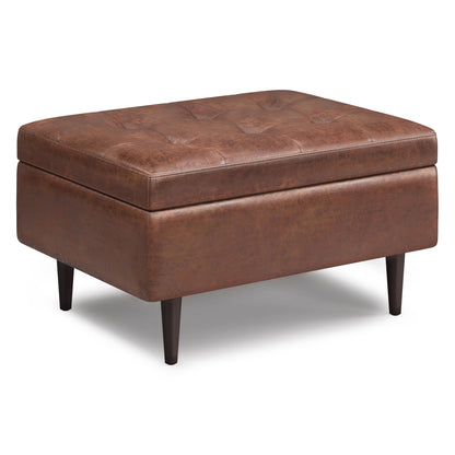 The Shay Large Square Coffee Table Storage Ottoman features brown tufted leather upholstery and tapered dark wood legs, shown against a white background in stylish mid-century design.