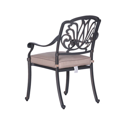 The Square 8 Person 64" Long Aluminum Dining Set With Cushions features black metal chairs with ornate backs, curved armrests, and light beige seat cushions secured to the frame.