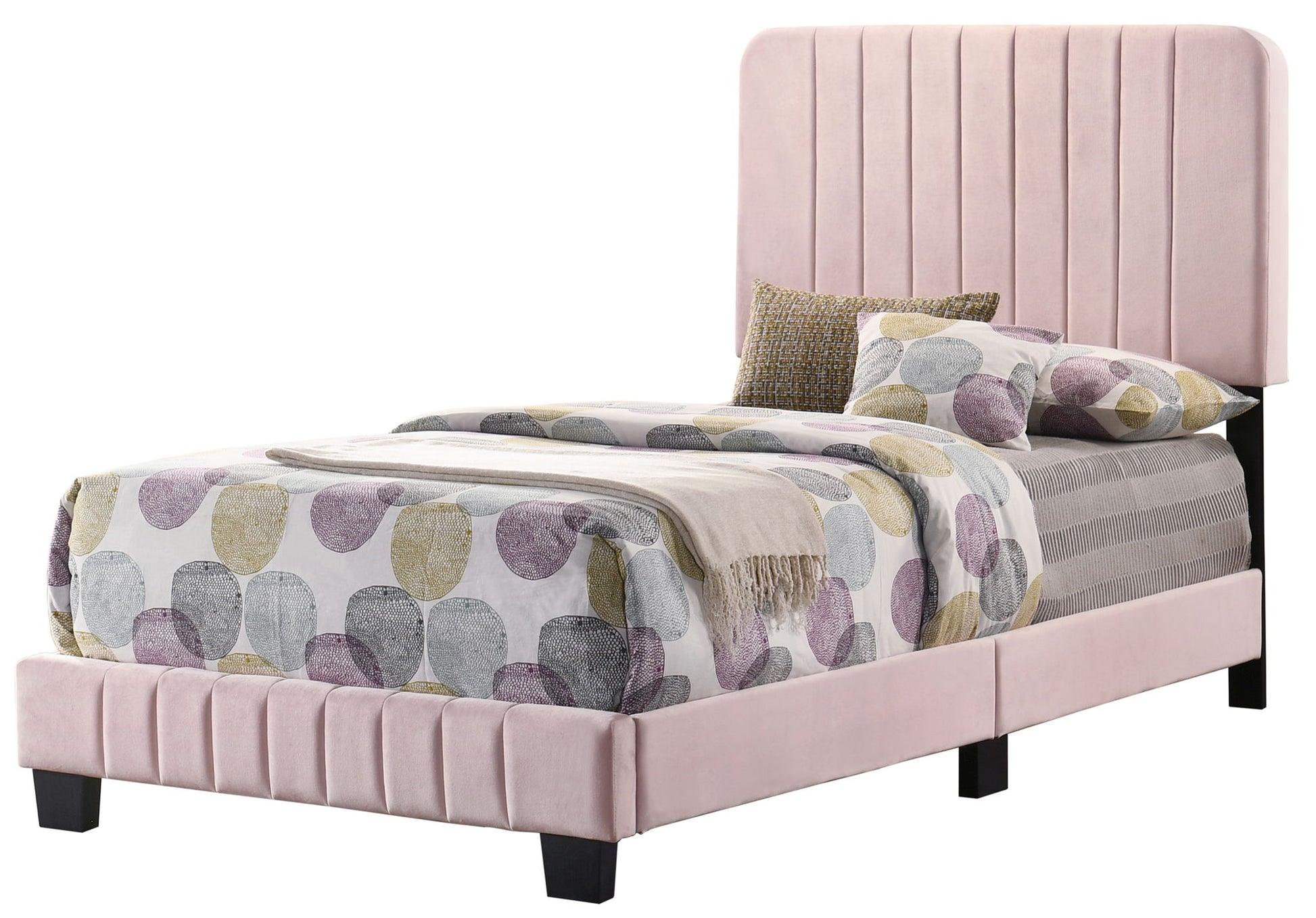 The Lodi - Bed is a modern twin with a tall, vertically paneled light pink upholstered headboard and footboard. It's styled with a duvet of large pastel circles, coordinated pillows, and a matching throw blanket.