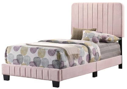 The Lodi - Bed is a modern twin with a tall, vertically paneled light pink upholstered headboard and footboard. It's styled with a duvet of large pastel circles, coordinated pillows, and a matching throw blanket.
