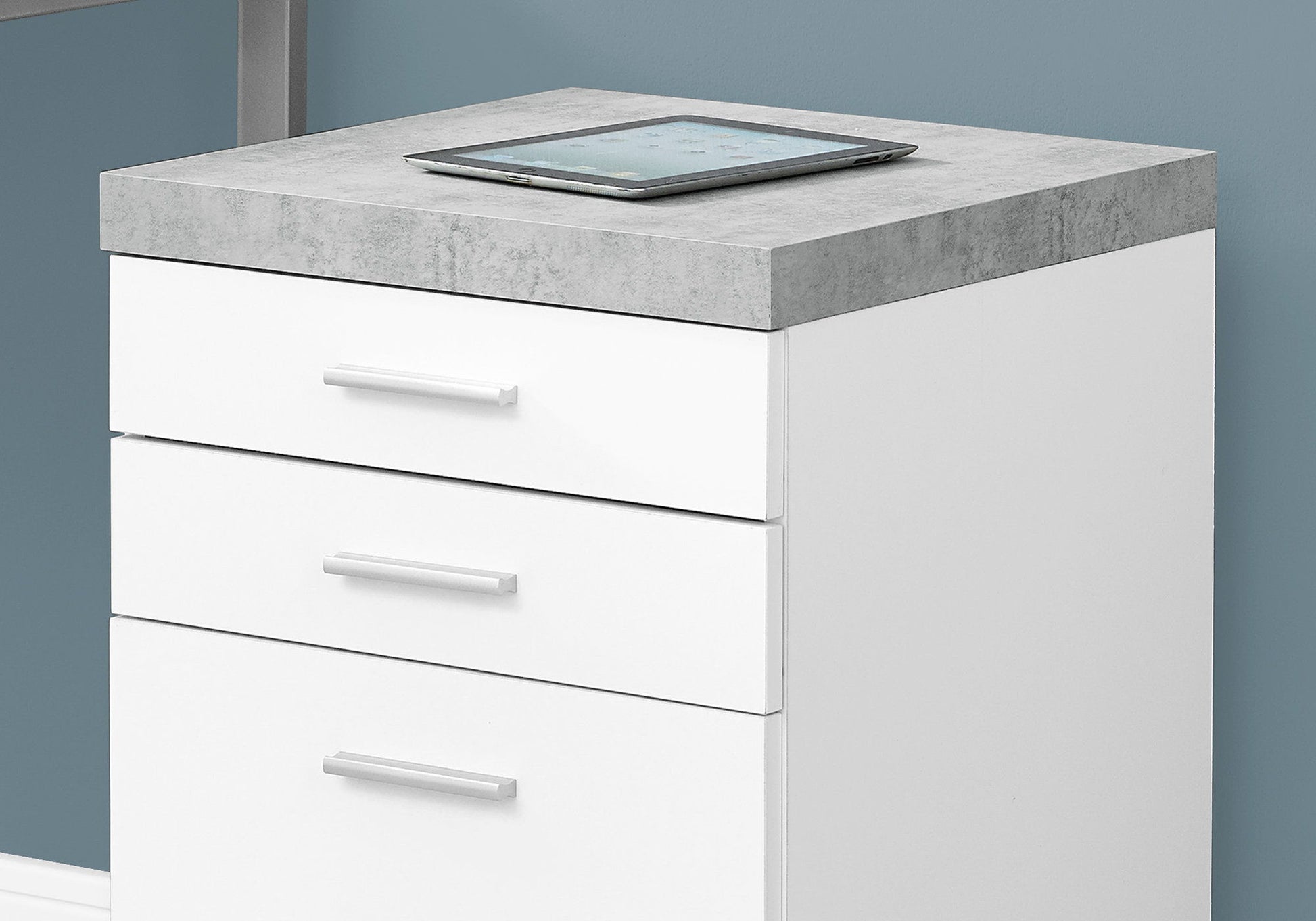 The File Cabinet Rolling Mobile Storage Drawers Printer Stand For Office with three white drawers and silver handles stands against a blue wall, with a digital tablet on its gray stone-textured top surface.
