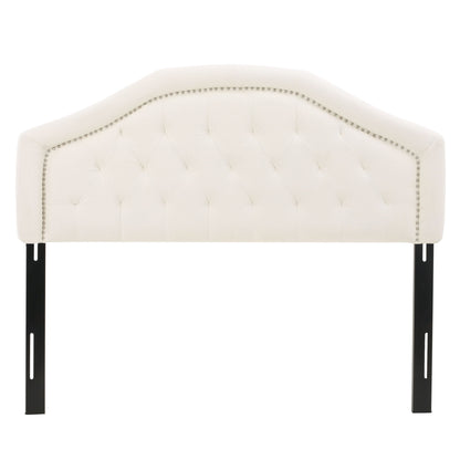 The Kaarina Contemporary Tufted Fabric Headboard features cream-colored upholstery, a curved top, silver nailhead trim, tufted design, and two black metal support legs.
