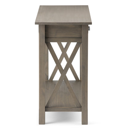Side view of the Kitchener - Handcrafted Table, showcasing a grayish wood finish, X-shaped cross brace design, and a lower shelf.