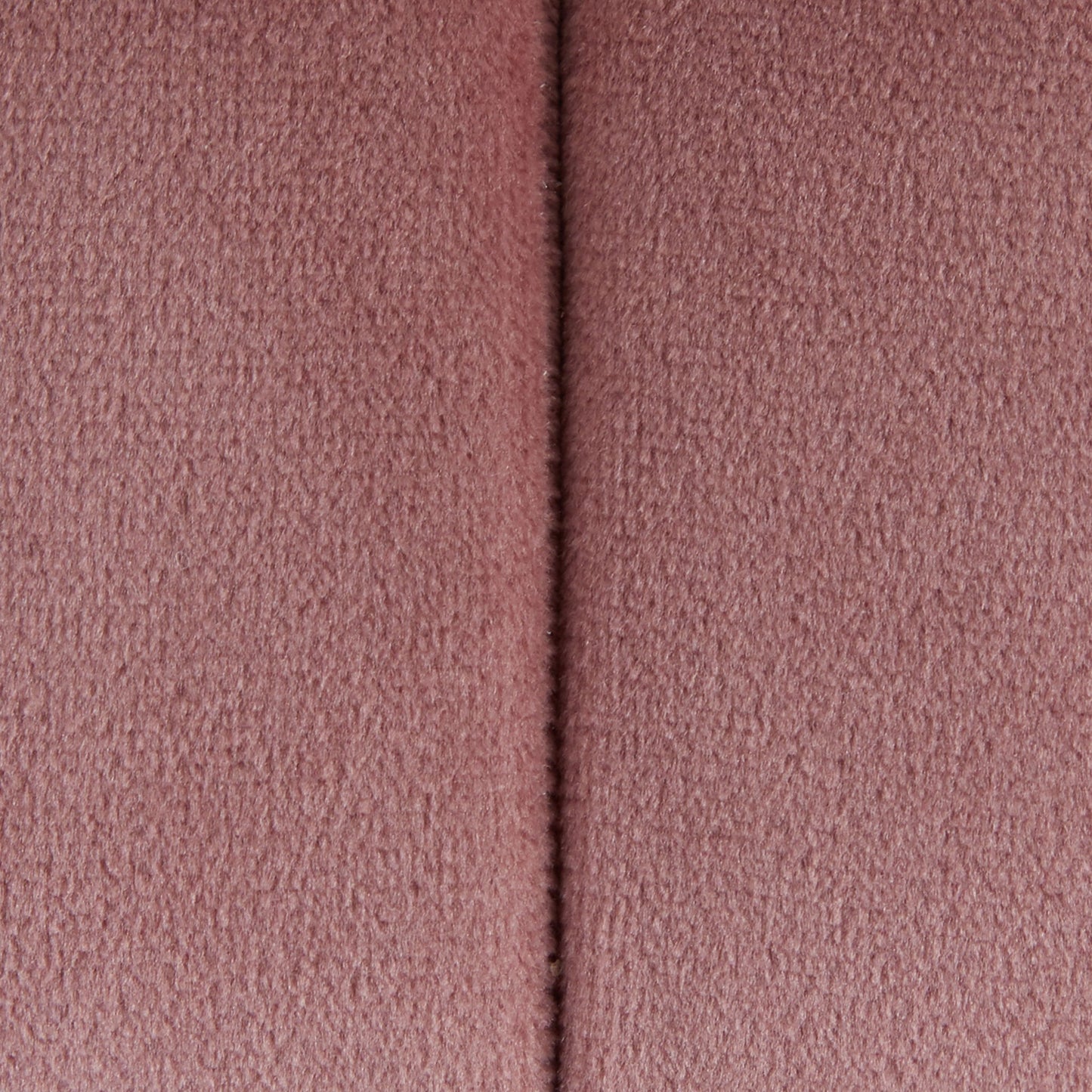 Close-up of the Braided - Versatile Round Ottoman, showing its soft pink textured fabric surface with a vertical seam down the center.