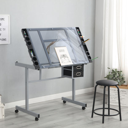 The Adjustable Art Drawing Desk Craft Station Drafting With 2 Non-Woven Fabric Slide Drawers And 4 Wheels - Silver holds a sketchbook and pencils, with storage drawers beneath. A black stool sits on a light wood floor by a window with curtains.