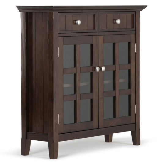 The Acadian Entryway Storage Cabinet in Brunette Brown features two small top drawers, two glass-paneled doors below with silver knobs, square legs, and a sleek modern design with a smooth polished finish.