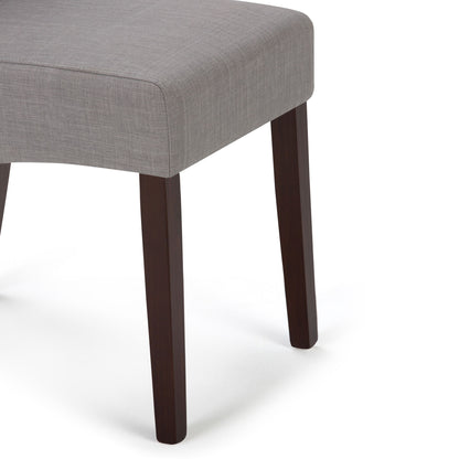 A close-up of the Avalon - Deluxe Parson Dining Chair set, featuring light gray upholstered seats and dark wooden legs, displayed against a white background.