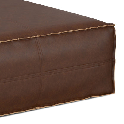 Close-up of the Brody Large Square Coffee Table Pouf, showcasing brown leather with visible edge stitching, a smooth, slightly glossy finish, and a boxy shape.