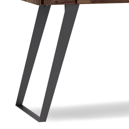 Close-up of the Lowry - Handcrafted Desk's black metal leg featuring an angled, geometric design, attached to its wooden tabletop against a white background.