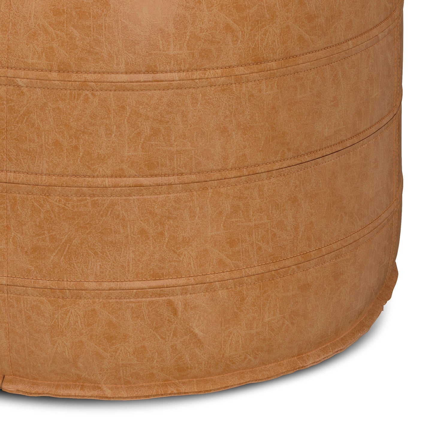 Close-up of the Brody - Round Pouf showcases its tan faux leather, visible stitching, and textured surface, emphasizing the material and fine craftsmanship of this stylish furniture piece.