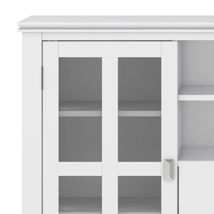 Close-up of the Artisan Handcrafted Tall TV Media Stand, featuring glass-paneled double doors with silver hinges and a metallic handle. Two interior shelves are visible through the glass panes.