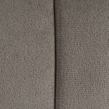 Close-up of the Braided - Versatile Round Ottoman’s textured gray fabric with a vertical seam down the center, dividing its surface into two sections.