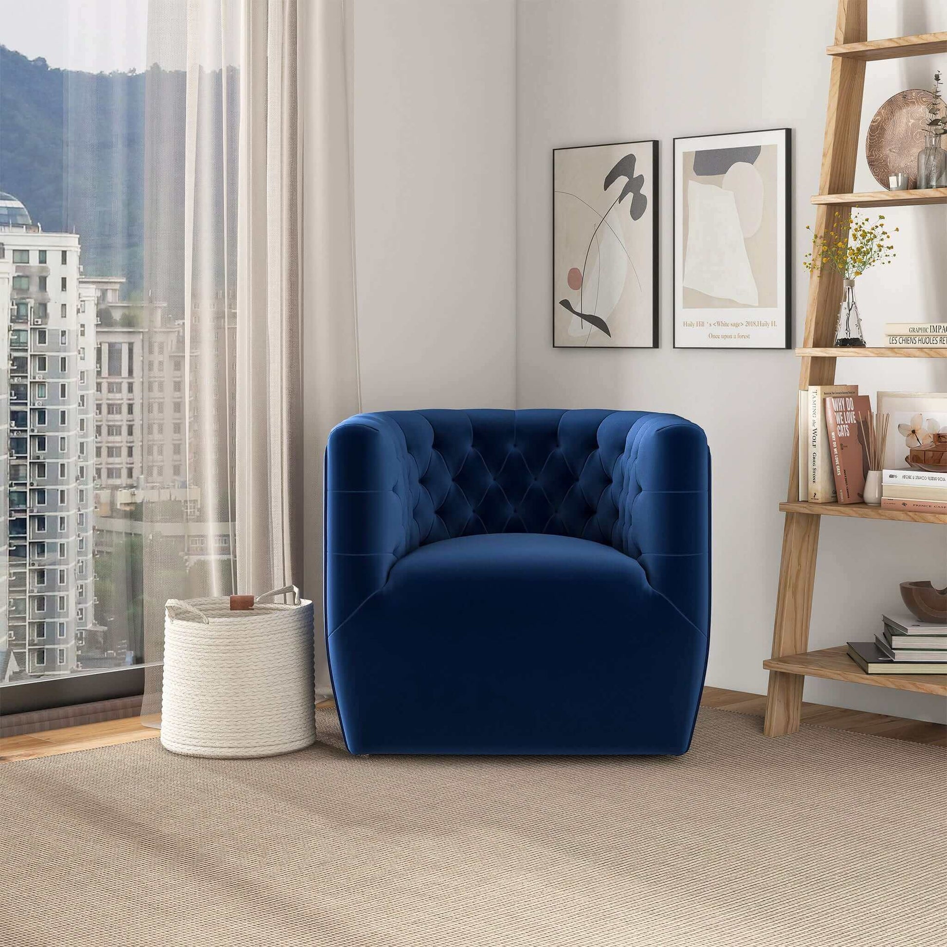 A modern living room featuring the Delaney Ergonomic Design Swivel Chair in blue velvet, a white woven basket, abstract wall art, a decor-filled bookshelf, large windows, and beige carpeting.