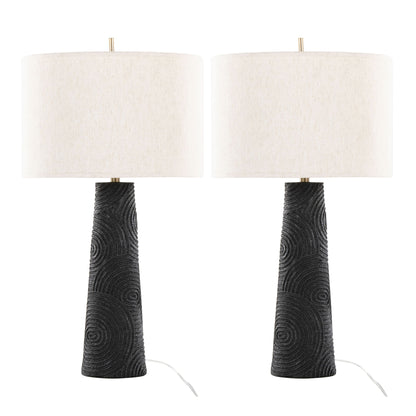 Set of 2 Kona Contemporary Table Lamps with textured matte black bases featuring circular patterns and large white drum lampshades. Visible cords at the base. Finish: Matte Black/Modern Brass/Natural.
