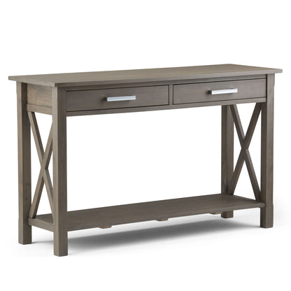 The Kitchener - Handcrafted Table is a wooden console table with a gray finish, two drawers with metal handles, X-shaped side supports, and a lower open shelf.