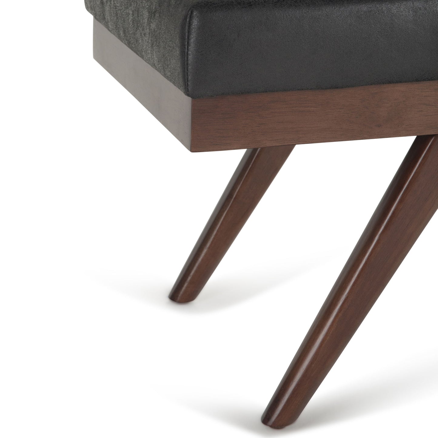 Close-up of the Chanelle Mid-Century Ottoman Bench, featuring a dark wood tapered leg, black upholstered cushioned seat, and wooden frame.