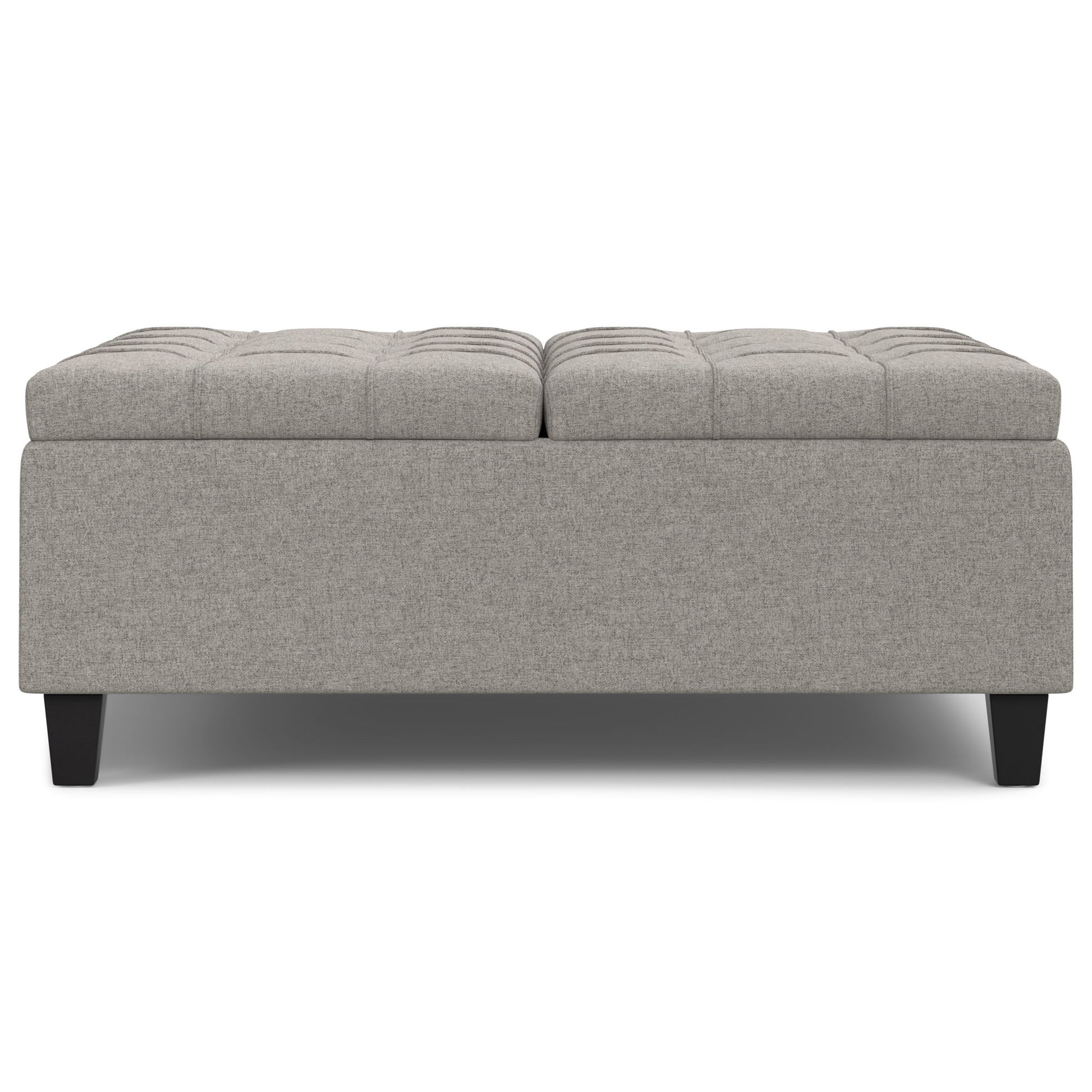 Harrison - Upholstered Coffee Table Storage Ottoman features a rectangular, light gray design with a tufted top and short dark wooden legs, displayed against a white background.