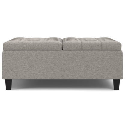Harrison - Upholstered Coffee Table Storage Ottoman features a rectangular, light gray design with a tufted top and short dark wooden legs, displayed against a white background.
