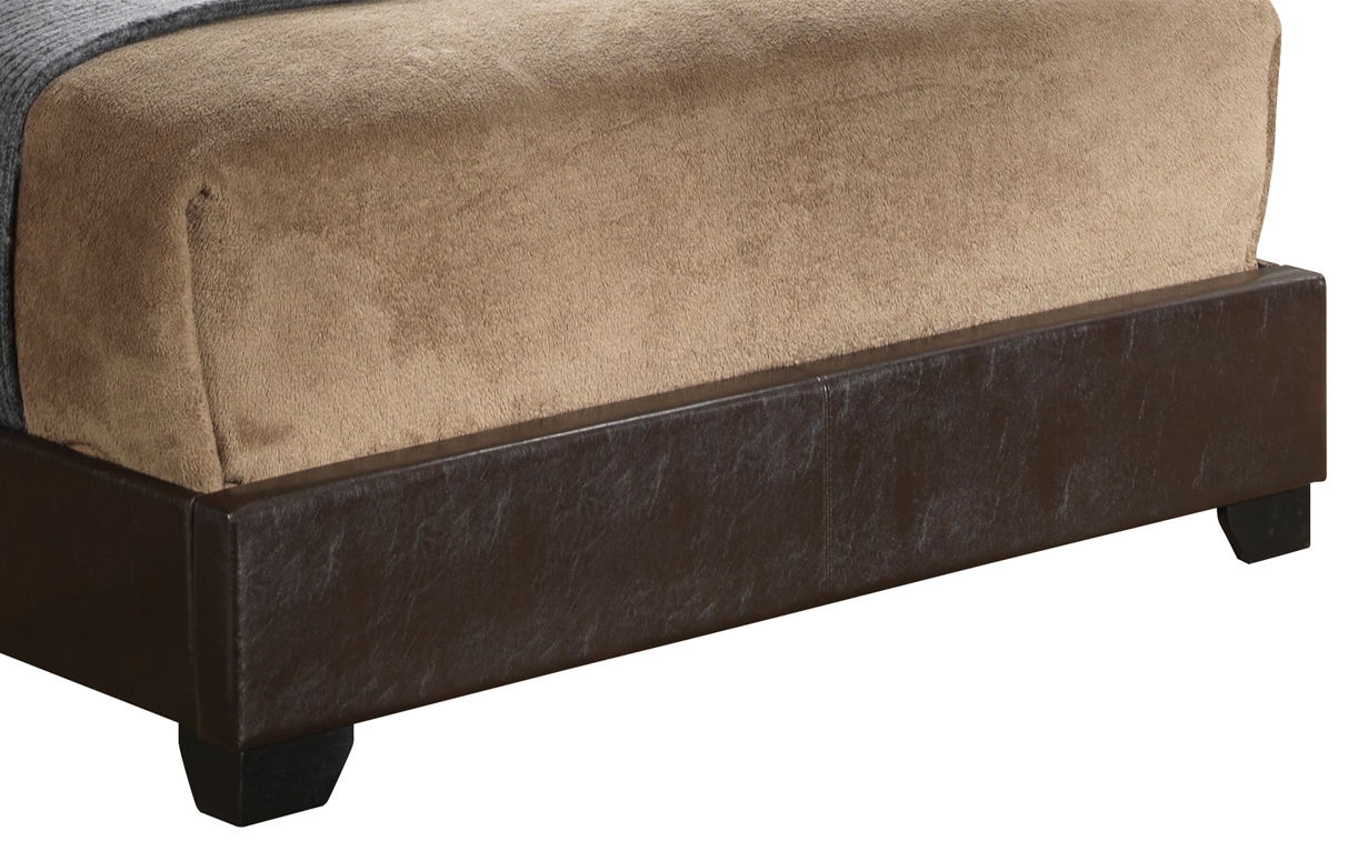 Close-up of the Elegant Platform Bed For Relaxed Spaces featuring a brown faux leather base, dark wooden legs, and light brown upholstered bedding on top.