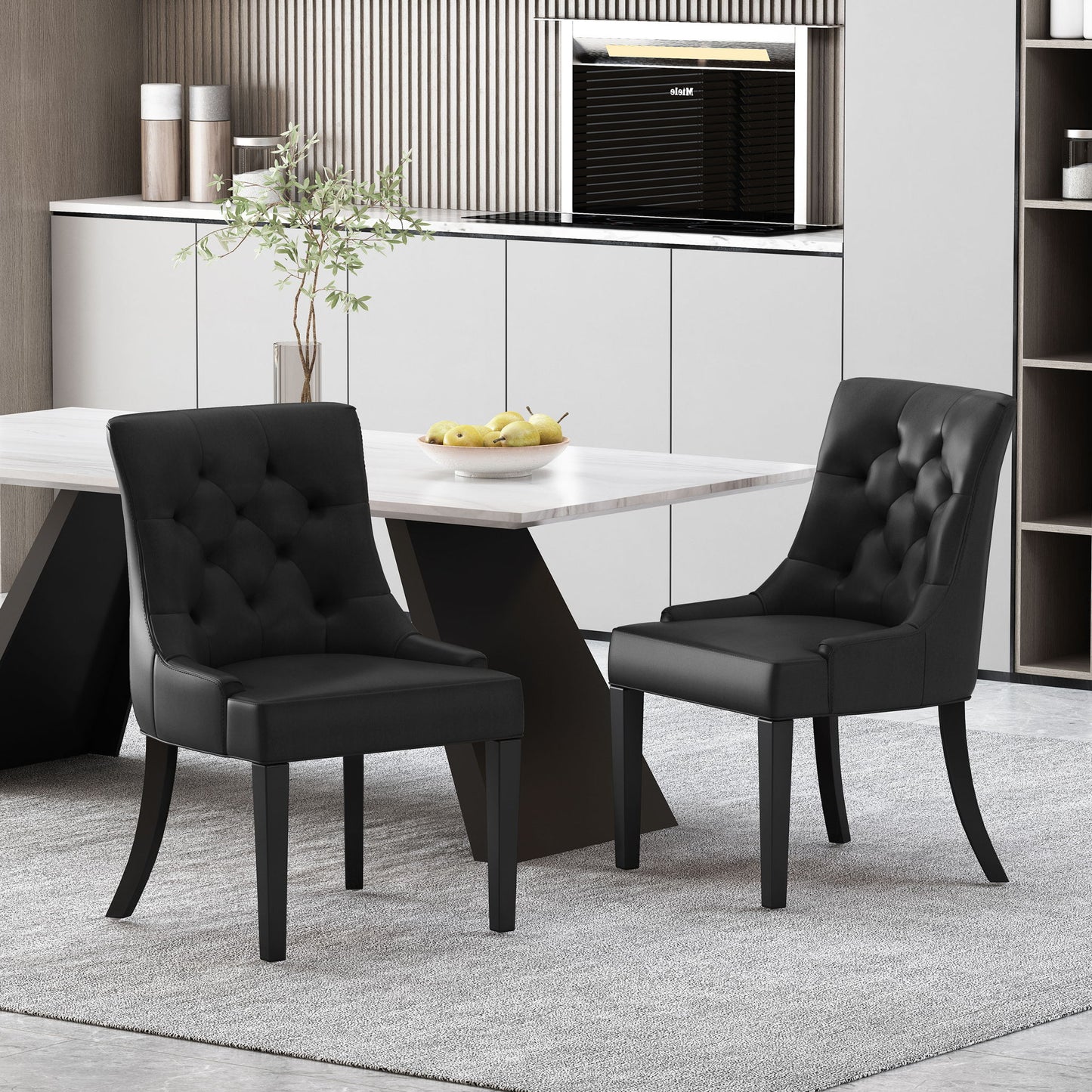 A set of two Cheney Contemporary Dining Chairs with tufted upholstery sit by a modern rectangular table on a light gray rug in a contemporary kitchen featuring white cabinets and minimalist decor.