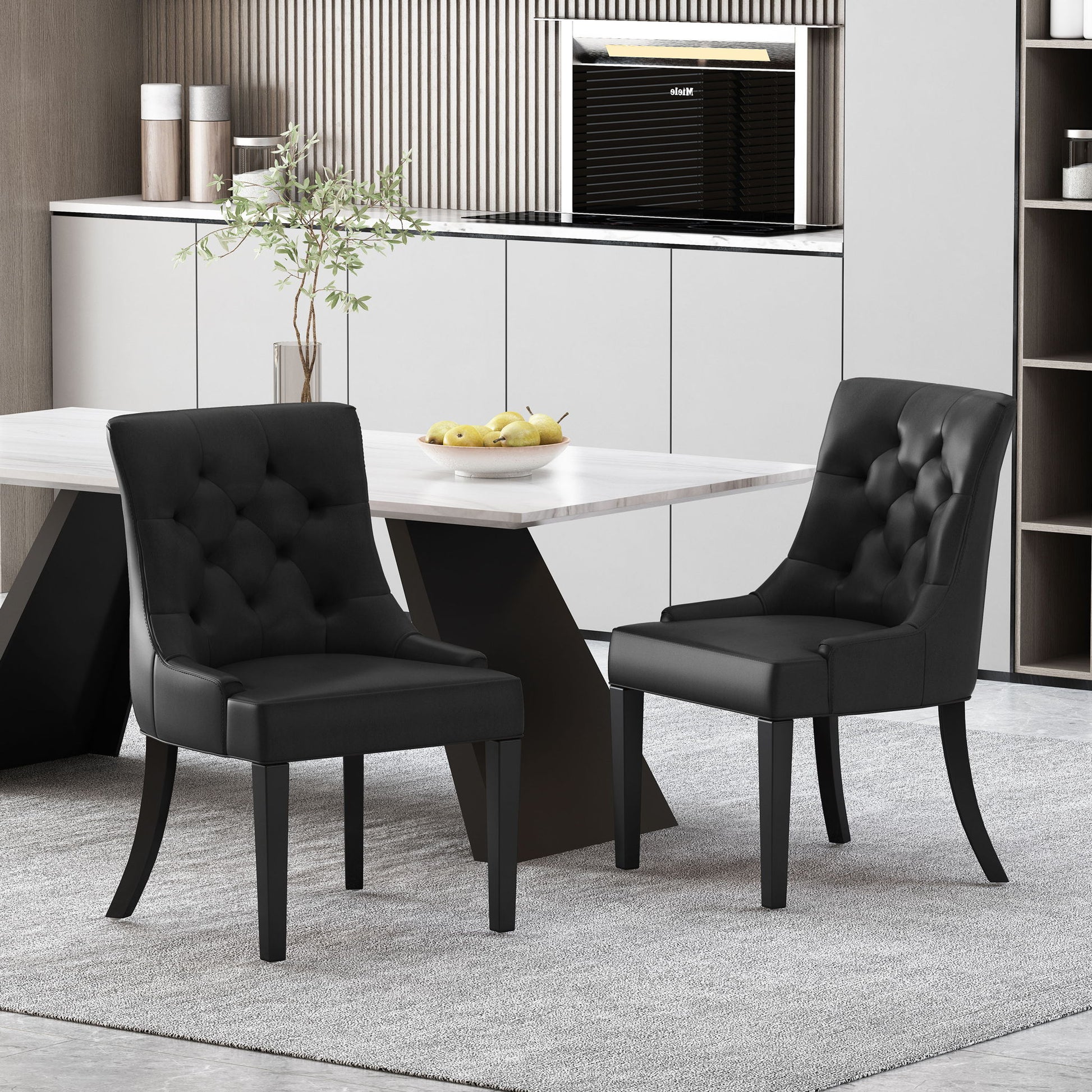A set of two Cheney Contemporary Dining Chairs with tufted upholstery sit by a modern rectangular table on a light gray rug in a contemporary kitchen featuring white cabinets and minimalist decor.