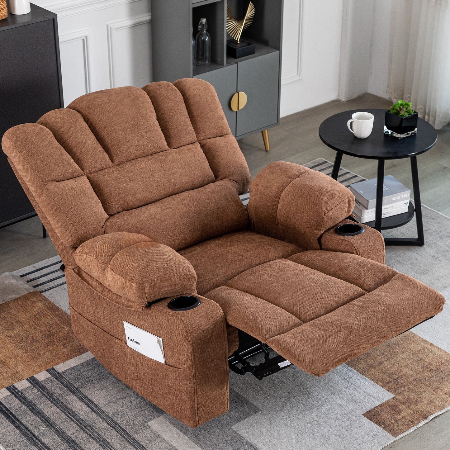 The Massage Recliner Chair Sofa With Heating Vibration, featuring cup holders and a side pocket, is extended in a cozy living room beside a black round side table with a coffee cup and a modern shelf unit with decor.