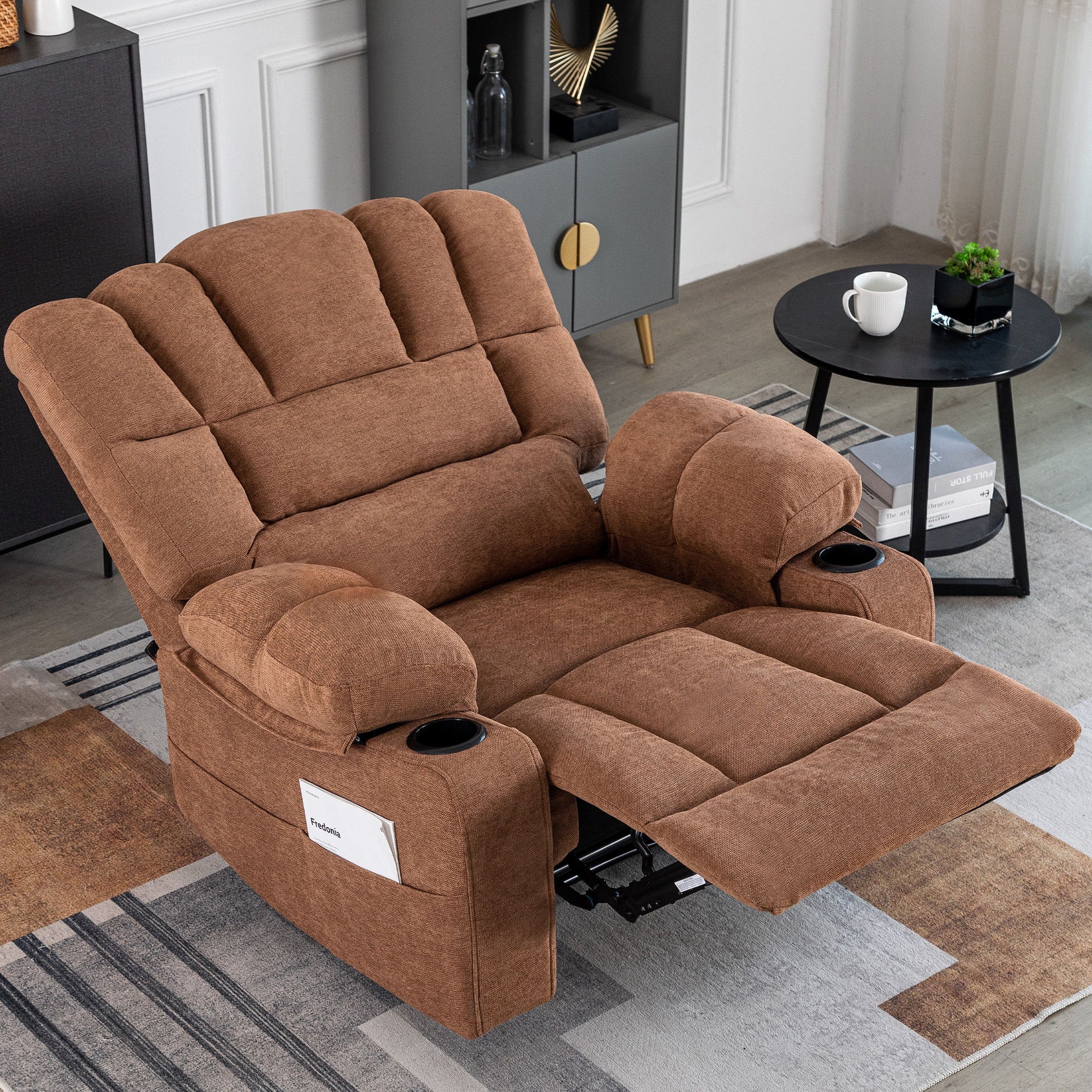 The Massage Recliner Chair Sofa With Heating Vibration, featuring cup holders and a side pocket, is extended in a cozy living room beside a black round side table with a coffee cup and a modern shelf unit with decor.