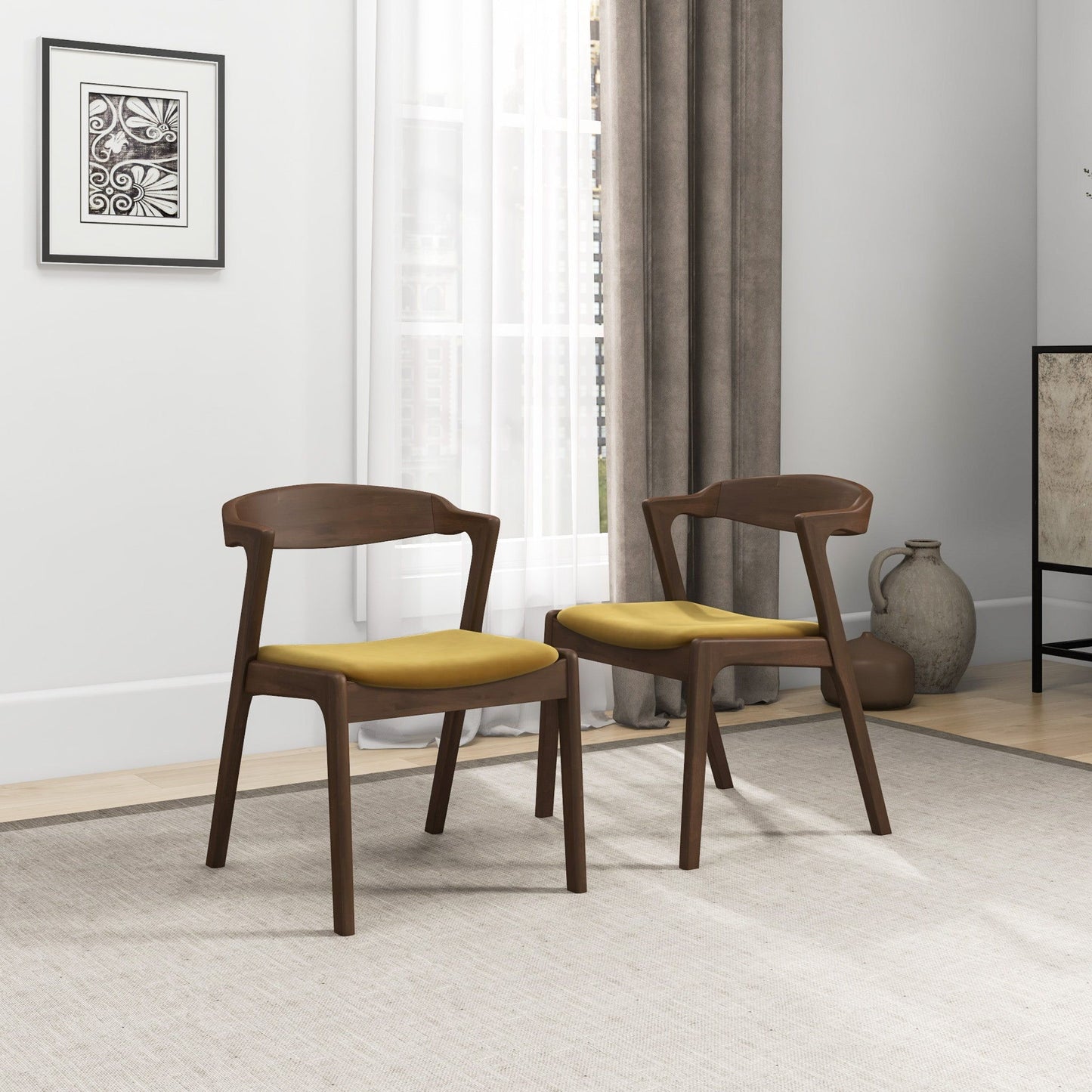 A pair of Dakota Mid-Century Modern Velvet Dining Chairs are set on a light rug in a bright room with a large window, gray curtains, framed art, and decorative vases in the background.