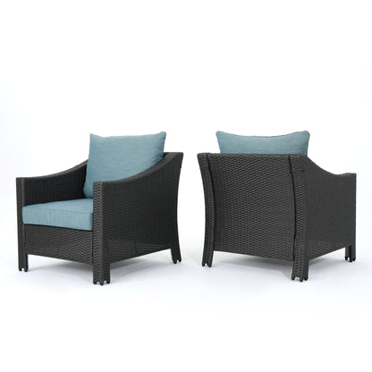 Two Antibes armchairs with water-resistant teal cushions and pillows are displayed on a white background; one faces forward, while the other shows the back.