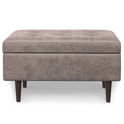The Shay Large Square Coffee Table Storage Ottoman features a tufted light brown upholstery and short dark wooden legs in mid-century style, shown from the front on a white background.