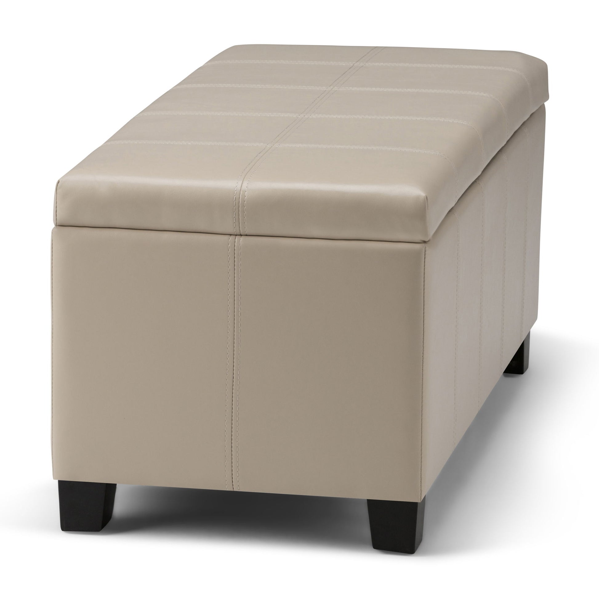 The Dover - Upholstered Storage Ottoman Bench is a rectangular beige ottoman with visible stitching and short, dark wooden legs, shown on a white background.